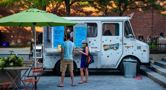 Couple standing in front of snow cone food truck